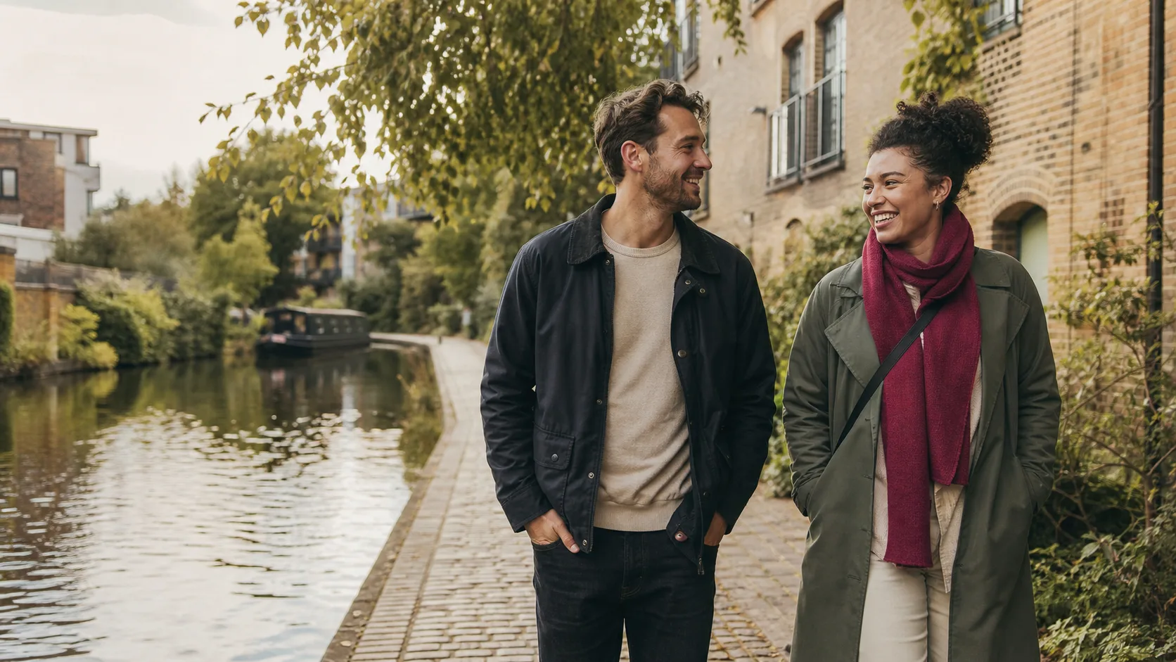 Two people chatting while walking beside a London canal